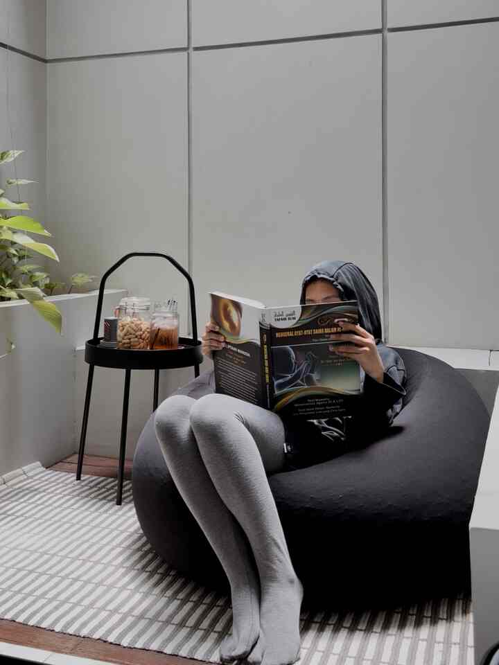 Gray and black toned small space featuring a bean bag and side table for a cozy reading nook
