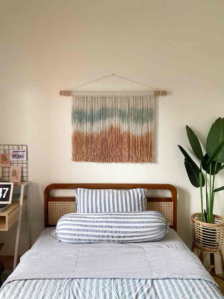 Beige natural tone bedroom featuring wooden bed with striped bedding, creating a cozy and relaxed atmosphere