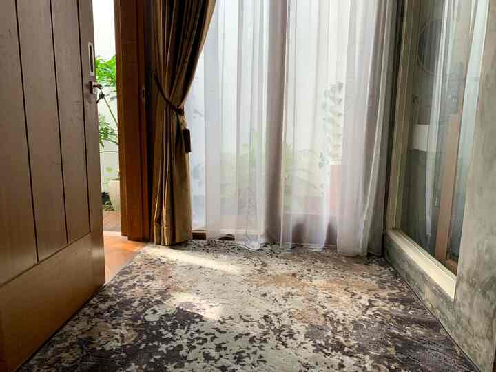 Gray and natural toned veranda featuring a large carpet and curtains with cozy atmosphere