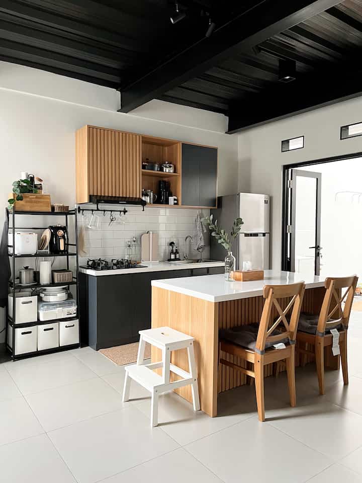 Halo! 
Salam kenal dari dapur #rumahmaknaa. 
Dapur ini kami desain sendiri, hasil modifikasi dari beberapa referensi yang kami suka. Lalu kami custom ke vendor kitchen set. 

Ukuran kitchen set kami hanya 180 cm tapi kami coba manfaatkan semaksimal mungkin. Salah satunya dengan movable kitchen island sehingga kalau kami butuh area kumpul yang lebih luas kami bisa menggeser kitchen island-nya. 

Desain area dapur kami adalah Japandi Industrial. Kami memadukan warna bold dan aksen raw (metal) dengan warna natural, aksen kisi-kisi juga kayu. Selain itu kami juga tambahkan warna hijau dari tanaman artificial agar terkesan lebih segar. 

Semoga menginspirasi 🤍🤍🤍



