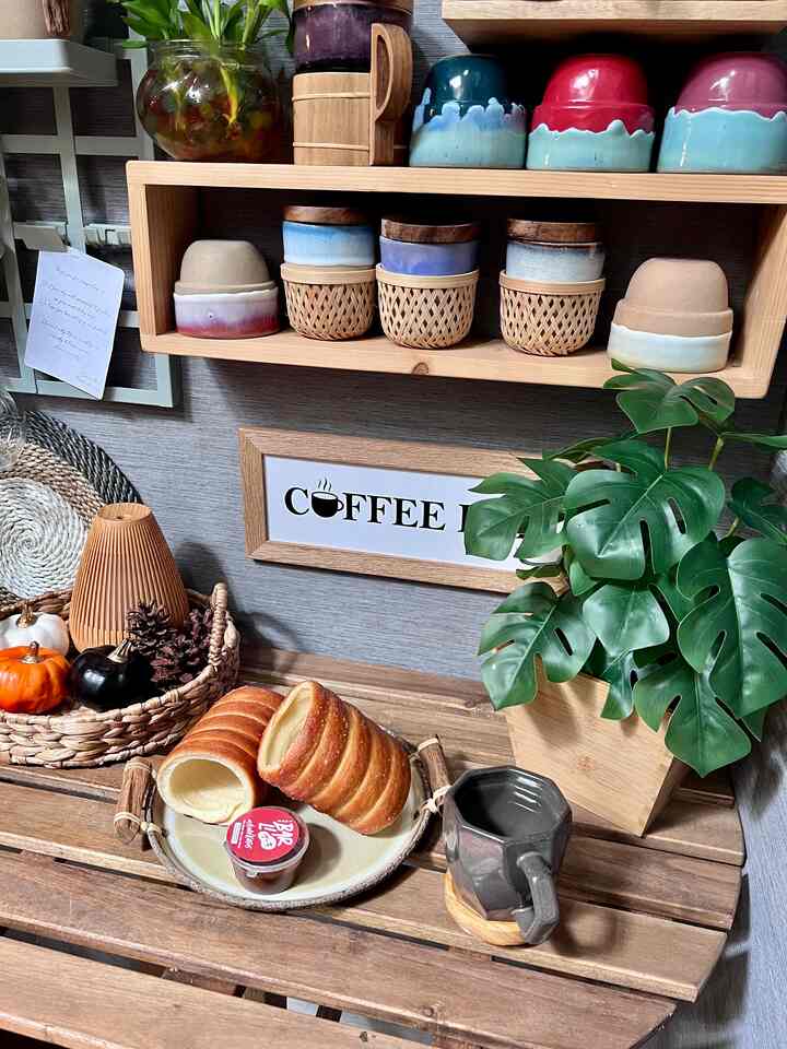 Natural-toned small corner space featuring wooden shelves, plant, and coffee tools creating a cozy home cafe interior