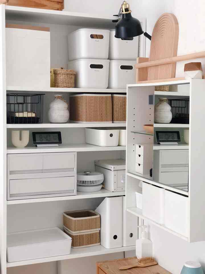 Natural-colored corner storage space with white shelving, organized boxes, and bathroom accessories, creating a clean and airy atmosphere