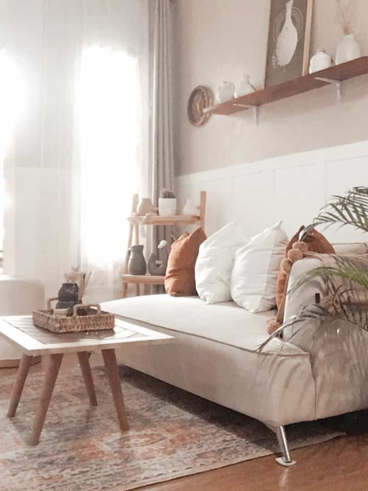 White and wood-toned Scandinavian living room featuring a beige sofa and rug with a natural and simple atmosphere