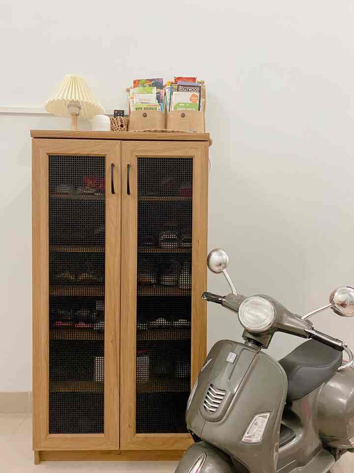 Small space with brown wooden cabinet and gray scooter against white wall