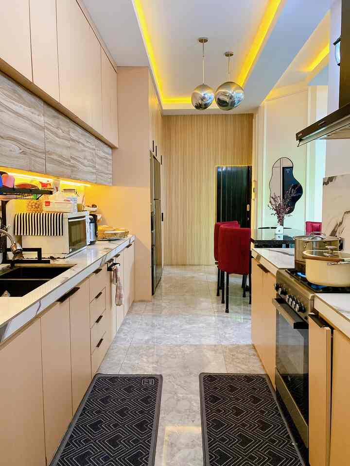 Natural modern kitchen in beige and wood tones featuring clean layout and red dining chairs, creating a warm inviting space