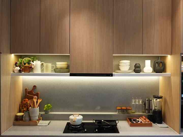 Natural kitchen featuring warm wood tones and white under-cabinet lighting, organized storage, and various kitchen utensils