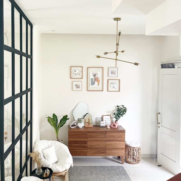 White and brown natural-toned entrance featuring wooden cabinet and rattan stool creating a warm atmosphere