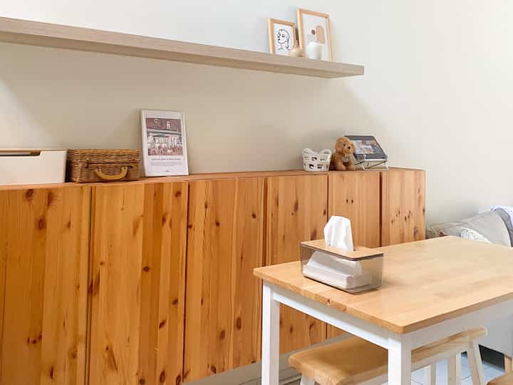 Beige-walled dining room with wood-tone furniture featuring a dining table and bench, creating a cozy and simple atmosphere