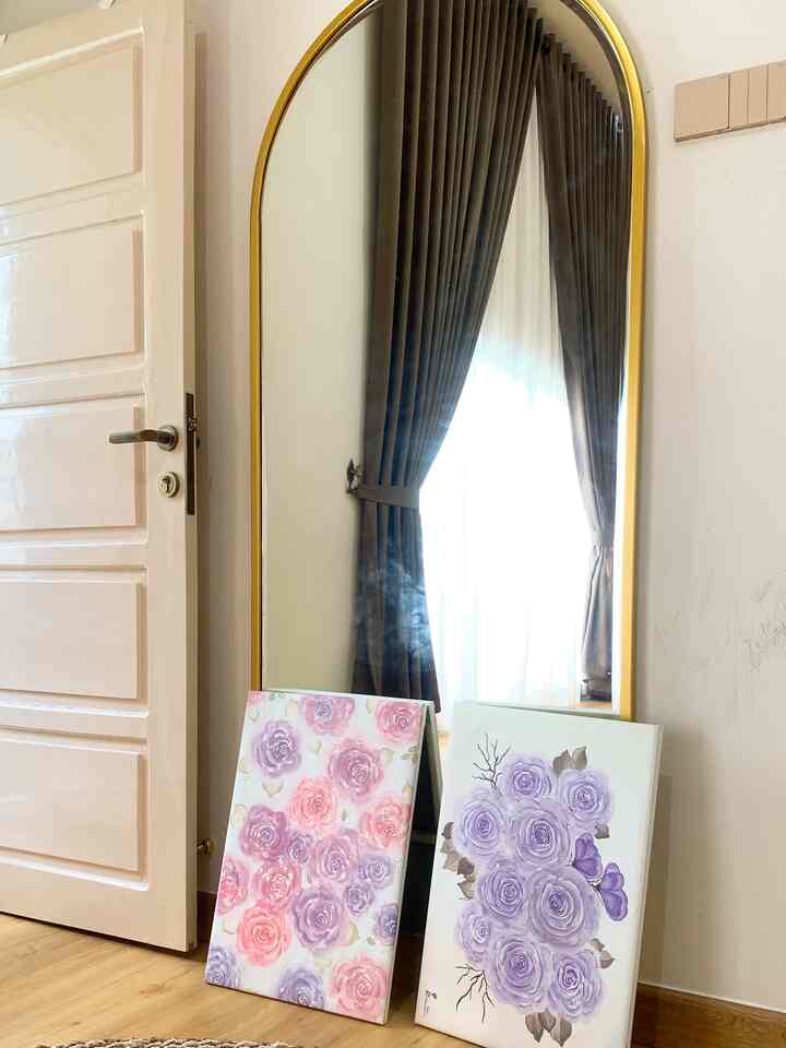 Natural-toned floor with a large standing gold-framed mirror in a simple residential corner