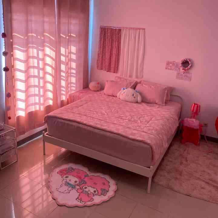 Pink-toned bedroom featuring a bed with pink bedding and blackout curtains, creating a cozy and neat atmosphere