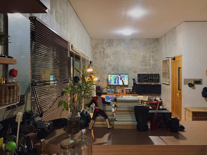 Natural color and industrial style harmonized compact living room featuring a TV stand, bookshelf, and retro accessories