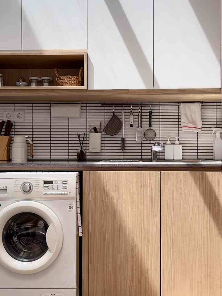White and wood tone kitchen featuring storage ideas in a minimal and compact space with natural light