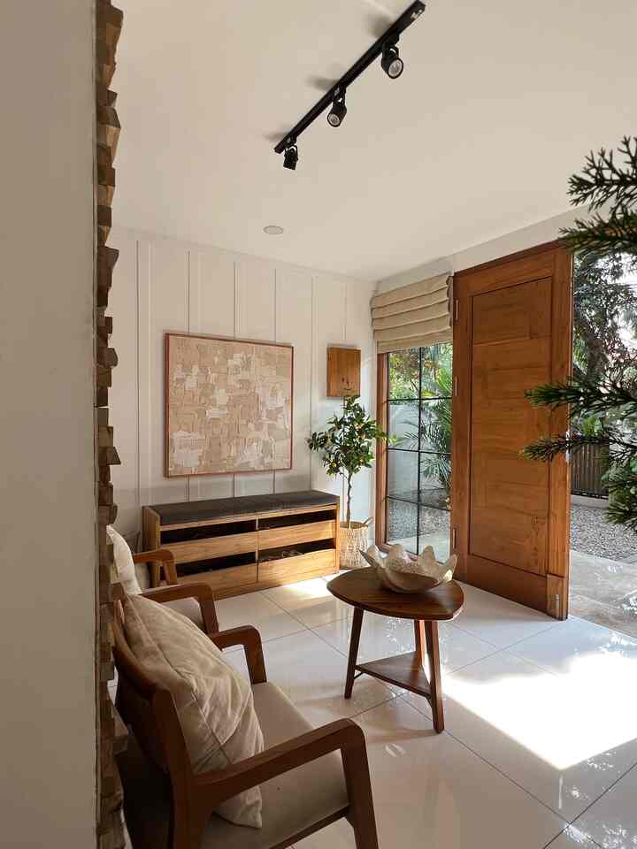 Natural and wood-toned compact entrance featuring wooden sofa, coffee table, and plants in a cozy setting