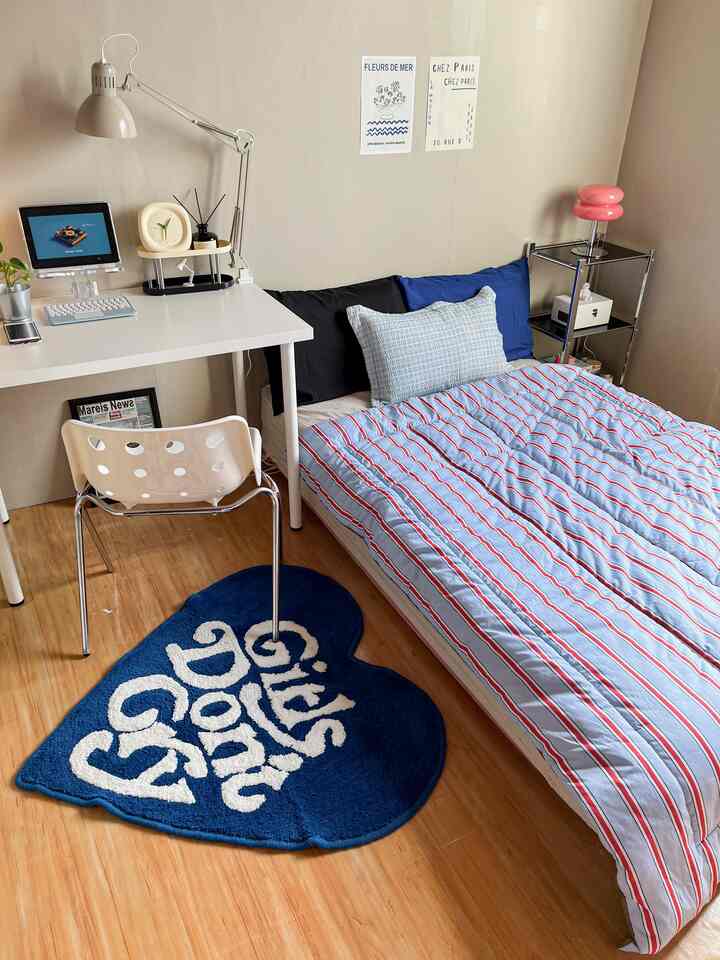 Sky blue toned bedroom featuring a white desk and blue bedding with a simple modern atmosphere