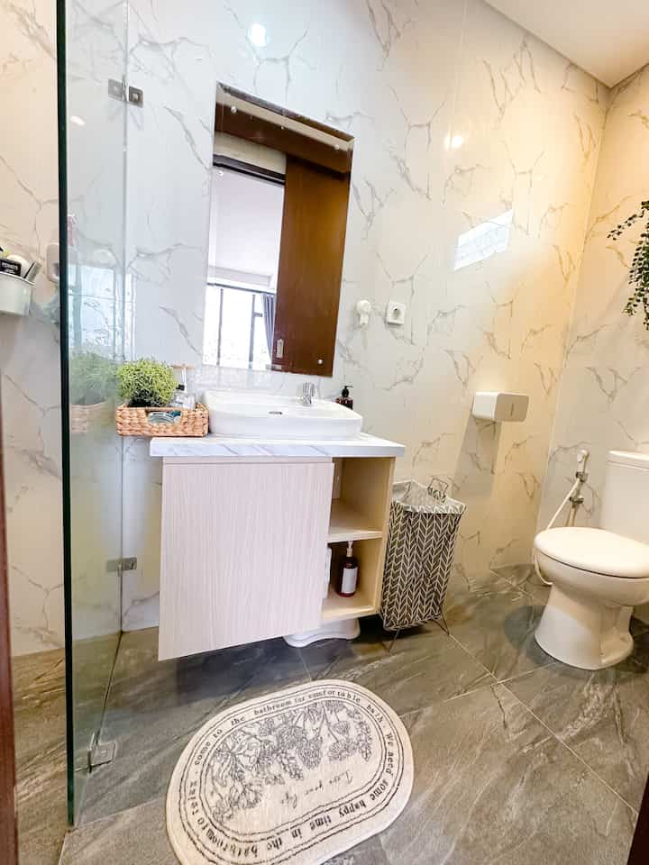 White and gray toned bathroom featuring sink and toilet in a compact space