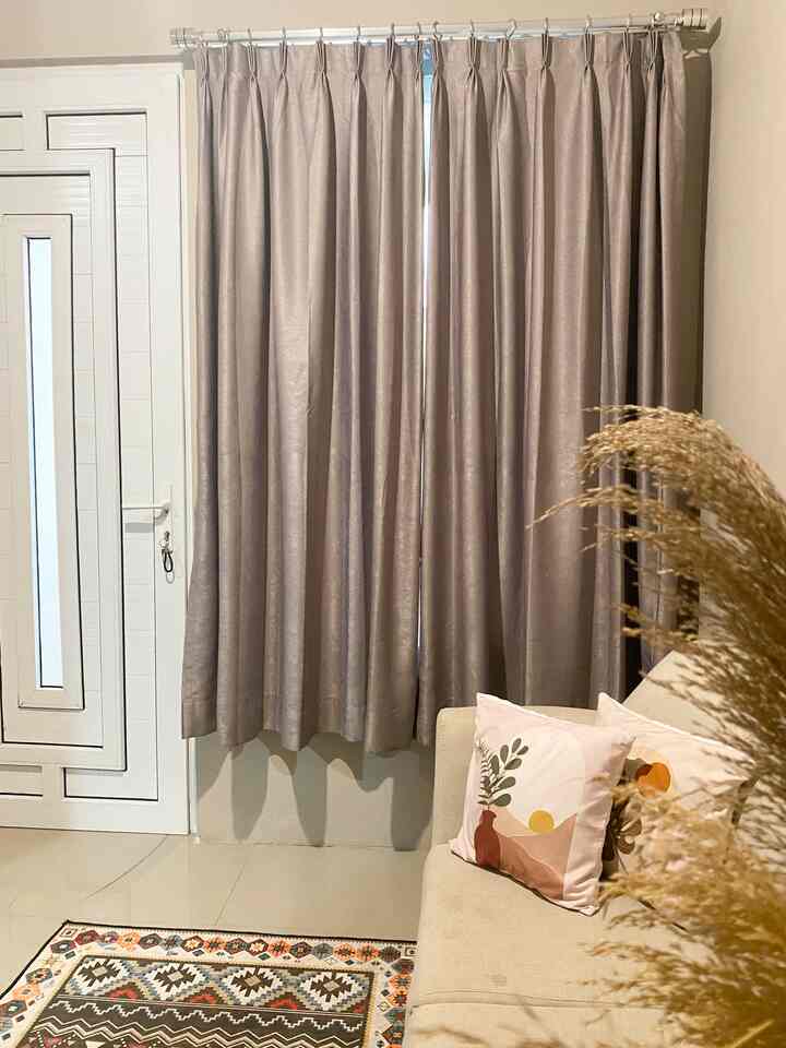 Beige sofa and black blackout curtains in a 2.7x3m minimalist living room space