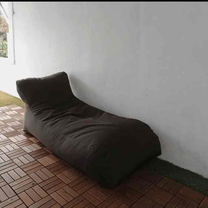 Brown bean bag lounger on balcony-style rooftop mini space with natural wooden flooring, creating a cozy natural atmosphere