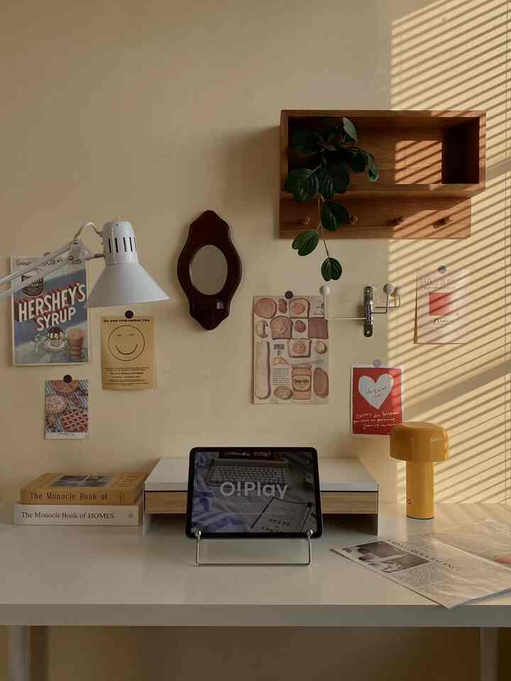 Beige-toned wall with white desk in home office space featuring vintage Korean decor and green plant for cozy atmosphere
