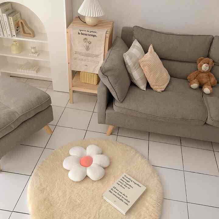 Small living room in beige and gray tones featuring a gray sofa and round beige rug creating a cozy atmosphere