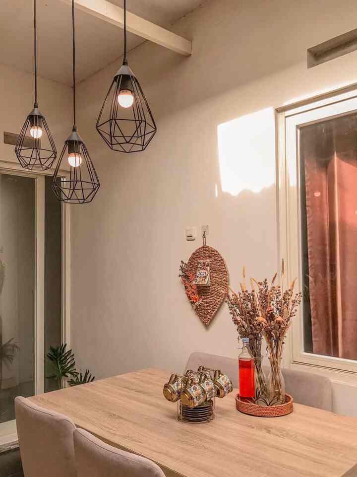 Natural toned dining room featuring wood-tone table, pendant lights, and dining chairs creating a warm and cozy atmosphere