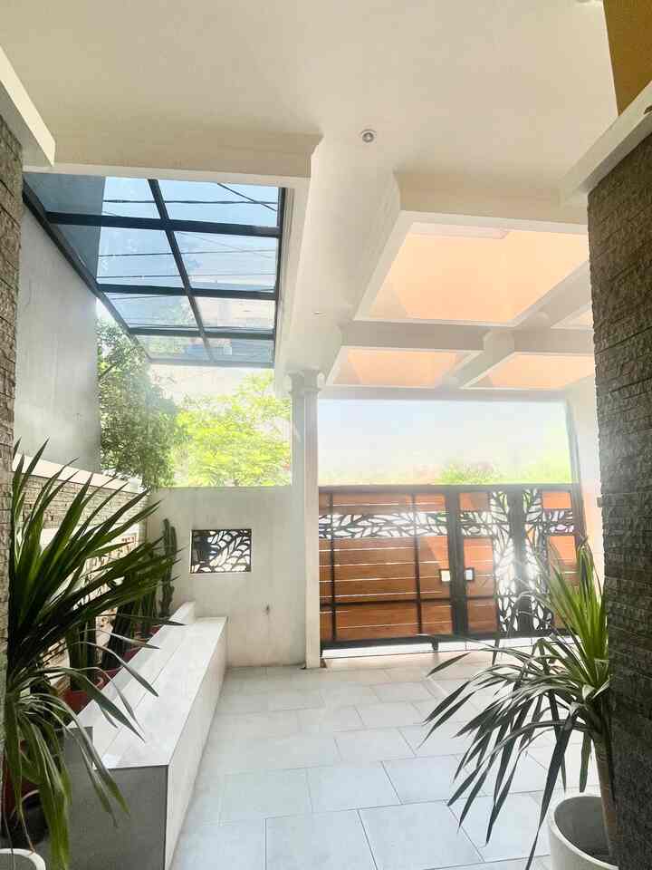 Natural color and wood tone entrance featuring natural stone walls and plants, creating a tropical house atmosphere