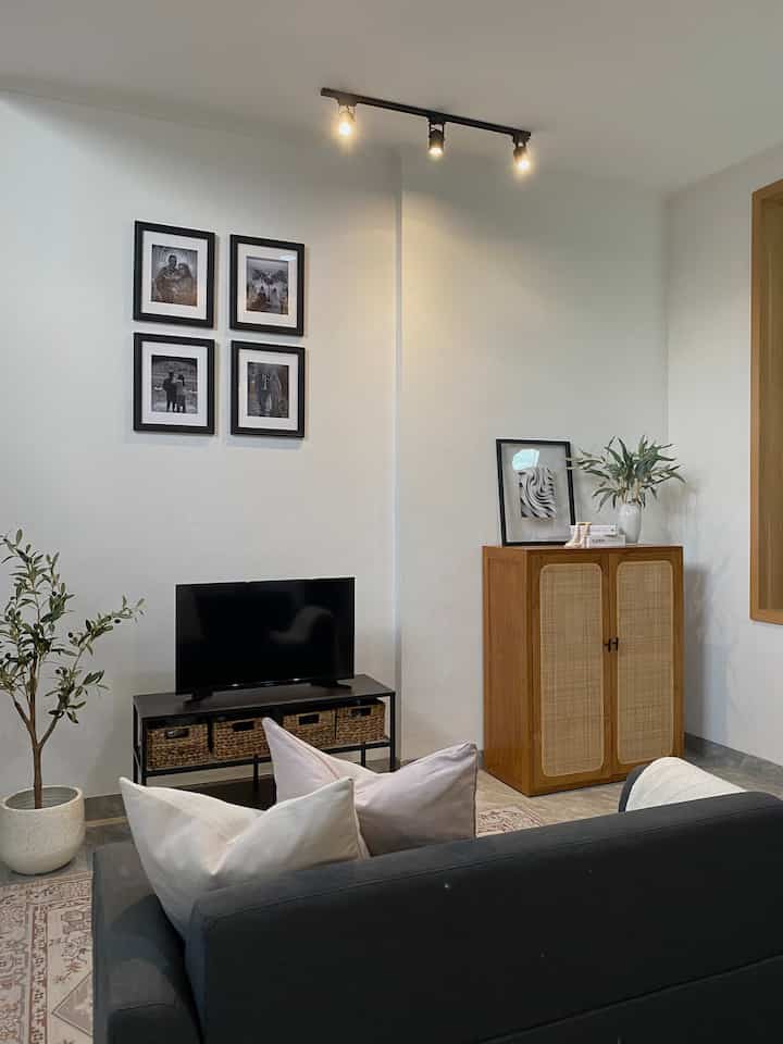 Our mini & comfy living room. Ukurannya tidak luas, tapi cukup. Mendekor / menata living room yg tidak terlalu besar menurutku cukup tricky, karena harus pintar-pintar dalam memilih furniture dan printilan dekor yg akan dipajang. 

Aku ingin menciptakan mood / ambience di living room senyaman dan se-hangat mungkin. Makanya kami menambahkan lampu sorot warna warm 
white yg dipantulkan ke dinding sehingga mendapat kesan syahdu. Selain itu, untuk living room ini kami memilih furniture-furniture yg simple dan minimalis agar tidak terkesan sempit ataupun ruangan menjadi penuh, diantaranya sofa dengan design minimalis 2 seater, meja tv, rak kabinet kayu jati mix rotan dan ditambah karpet agar lebih homey.

Untuk mendapatkan furniture / barang dekor tentu saja kami sering browsing ke berbagai macam e-commerce ataupun mendatangi toko home decor seperti Ikea, Informa, Dekoruma. Karena di sana banyak banget inspirasi unfuk keperluan rumah. 

#livingroomstyling #livingroomdecor #livingroommakeover #homeinspo #rumahmodern #inspirasirumah #tinyhome #rumahdeveloper