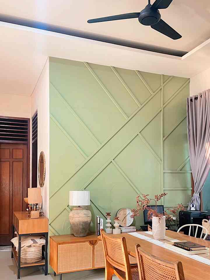 Natural brown tone living and dining room featuring a dominant green wall panel and wooden furniture with warm accents