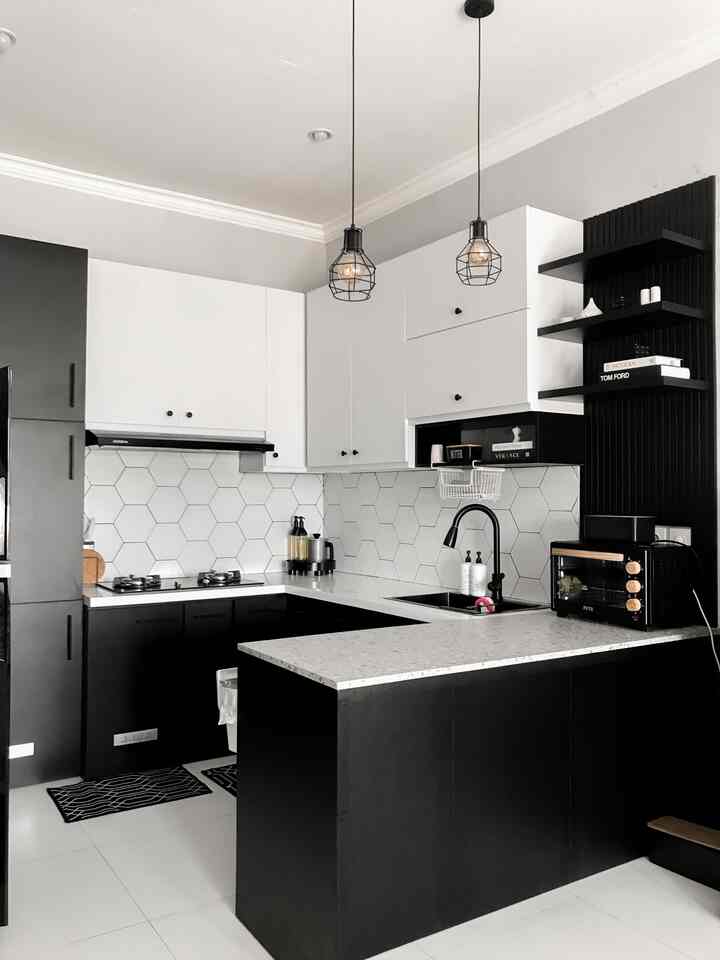 Modern black and white kitchen featuring a U-shaped layout and pendant lights, creating a clean and sleek space