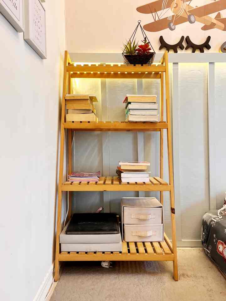 Light wood tone Scandinavian kids' room featuring a wooden shelf rack filled with books and storage boxes