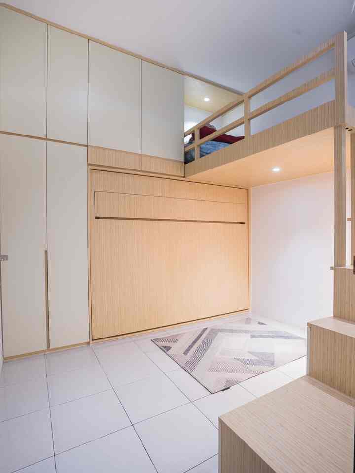 Compact kids' room with white tiled floor and wood tone furniture featuring a loft bed and built-in cabinets for storage