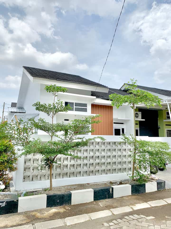 Fasad GH House - Before After Edition

Fasad bawaan developer hasil perjalanan renovasi ini awal mulanya belum memiliki pagar. Akhirnya saat renovasi kita buat pagar beton roster gaya minimalis yang lagi tren saat itu (tahun 2022). Warna awalnya pun hijau terang dan oranye, lalu kita ubah jadi warna White, sedikit Grey dan Brown supaya looks nya natural. Belum berkanopi depan, hanya ada kanopi samping untuk atap area laundry

Awal 2023 memutuskan pasang kanopi depan berbahan Alderon RS dan pagar perforated metal. Alasannya karena rumah ada di posisi sudut dan menghadap timur, kalau siang cuaca panas langsung mengarah ke rumah, jika musim hujan, air yang dibawa angin lama-lama merusak pintu dan juga membuat dinding jadi mudah lembap. Jadilah fasad yang sekarang seperti di slide 4 dan 5, jadi agak sedikit tertutupi dengan adanya kanopi shape L di teras

#DesignFasad 
#IdeFasad
#InspirasiFasad
#FasadRumahMungil
#RumahMinimalis