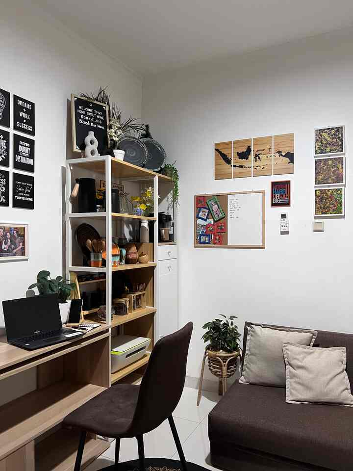 White and brown toned home office space featuring desk, sofa, and plants with cozy working atmosphere