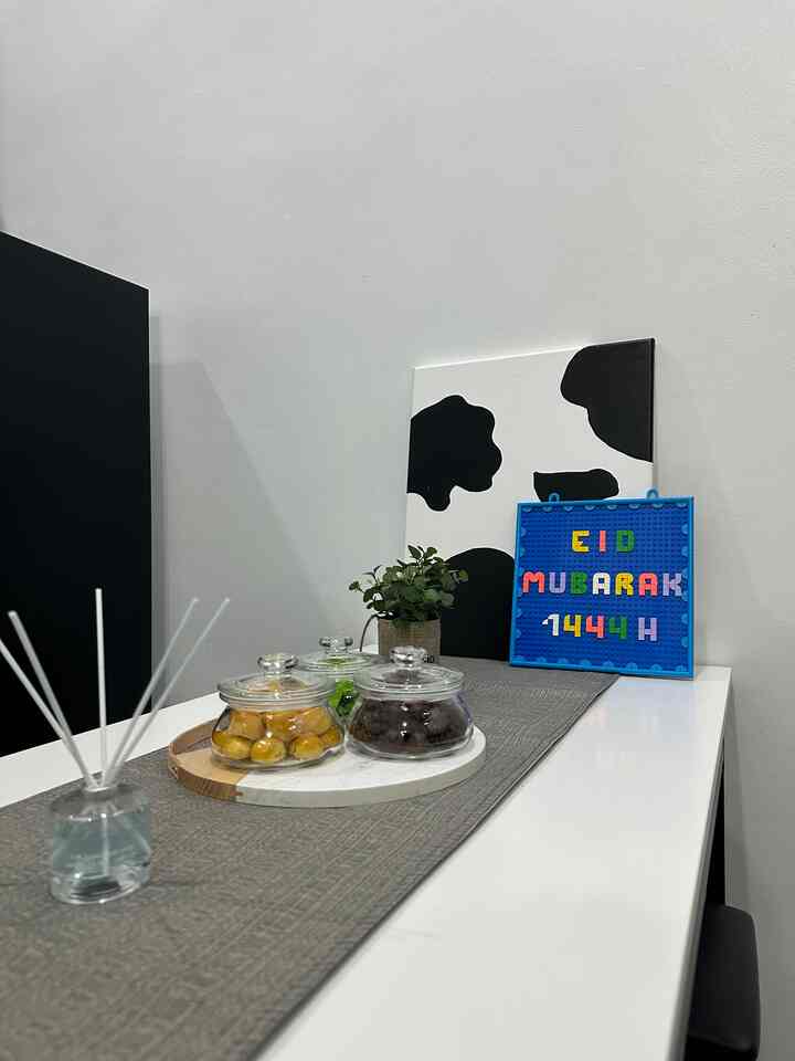 Gray table runner on white dining table with simple decor in a minimalistic 4-person dining room space