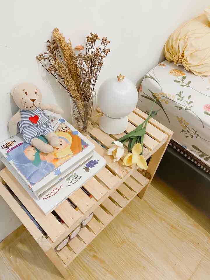 Bright wood tones and white walls in a kids' room featuring toy shelf, books, and floral bedding creating a cozy atmosphere