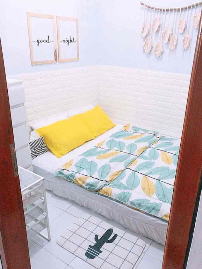 White and yellow toned 6-tatami bedroom featuring a neat bed and storage chest in a simple space