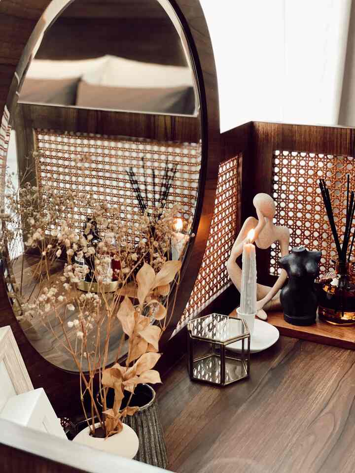 Natural-toned bedroom featuring vintage mid-century modern vanity, rattan decor, and dried flowers creating a warm atmosphere