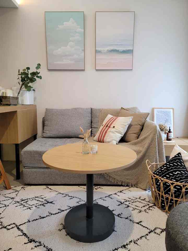 Simple Japandi style living room with natural wood tones and grey sofa creating a calm atmosphere