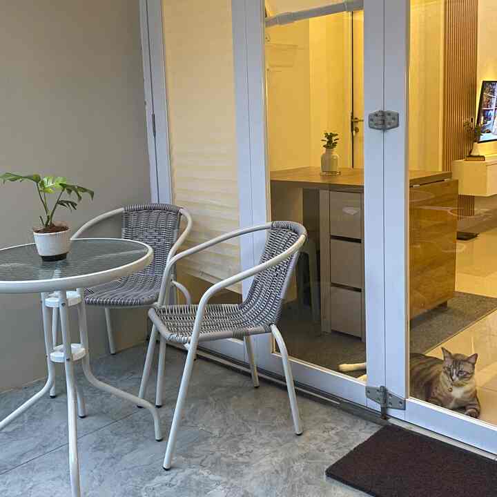 White and gray toned veranda featuring folding door, outdoor table and chairs with a minimal atmosphere