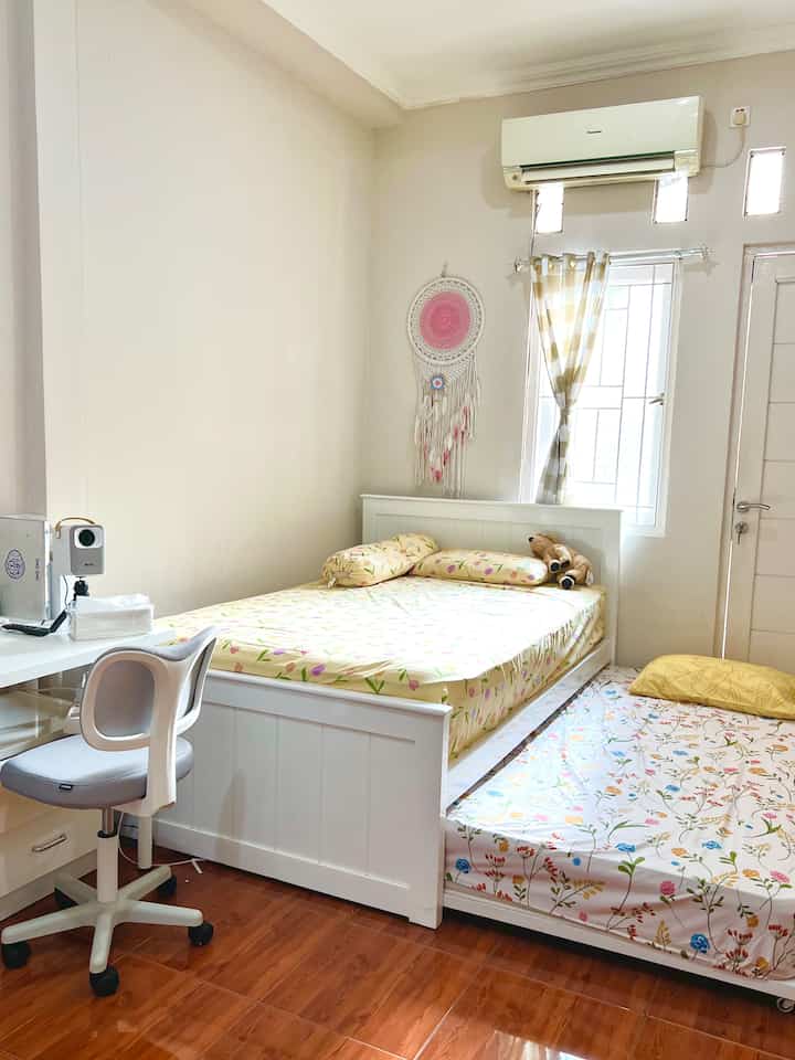 Bright white and wood tone kids' bedroom featuring custom twin beds and a desk creating a cozy atmosphere