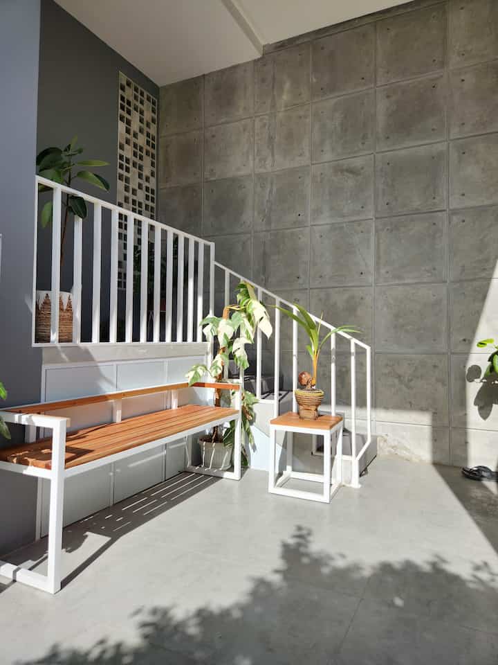 Teras Rumah Semak. Karena kami tidak punya ruang tamu, kami menyediakan bangku panjang dan meja untuk tamu yang tidak dekat. Biasanya tamu yang dekat seperti saudara dan teman akan langsung masuk ke living room.

Tema teras ini yaitu industrialis tropis, dan sengaja dibuat naik ke atas dengan tangga karena dulu rumah kami berada di kawasan banjir. Tema industrial dapat dilihat dari penggunaan semen ekspos di dinding, dan ubin granit berwarna abu-abu dan semen.

Untuk dekorasi, kami lebih banyak menaruh tanaman hidup agar teras terlihat segar, dipadu dengan coverpot tradisional dari pot terakota, purun dan eceng gondok.

Kami juga menyediakan tempat cuci tangan, jadi setiap pulang ke rumah atau habis berkebun, bisa menggunakan wastafel dari batu. Dipilihnya wastafel dan backsplash dari batu agar tema tropis lebih melekat di teras ini. 

#tropicalhome #industrialhome #teras #terasrumah 