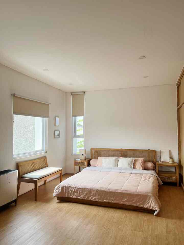 Beige and wood-tone bedroom featuring a simple wooden bed and nightstands, bright and warm minimalist atmosphere