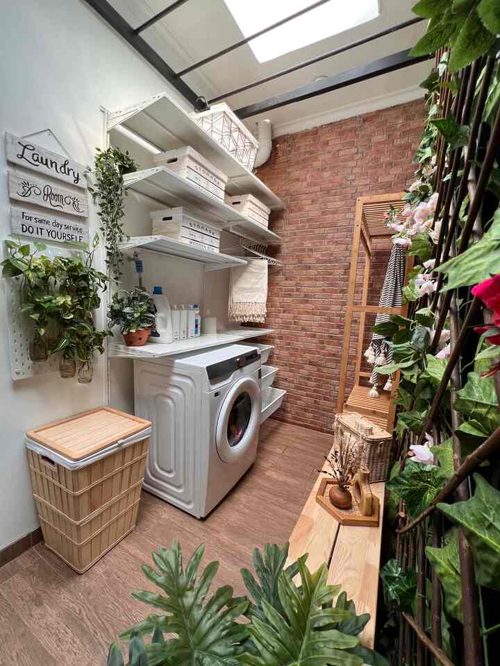 Warm natural-toned narrow laundry room featuring white washing machine, wooden shelving, and green plants creating a clean atmosphere