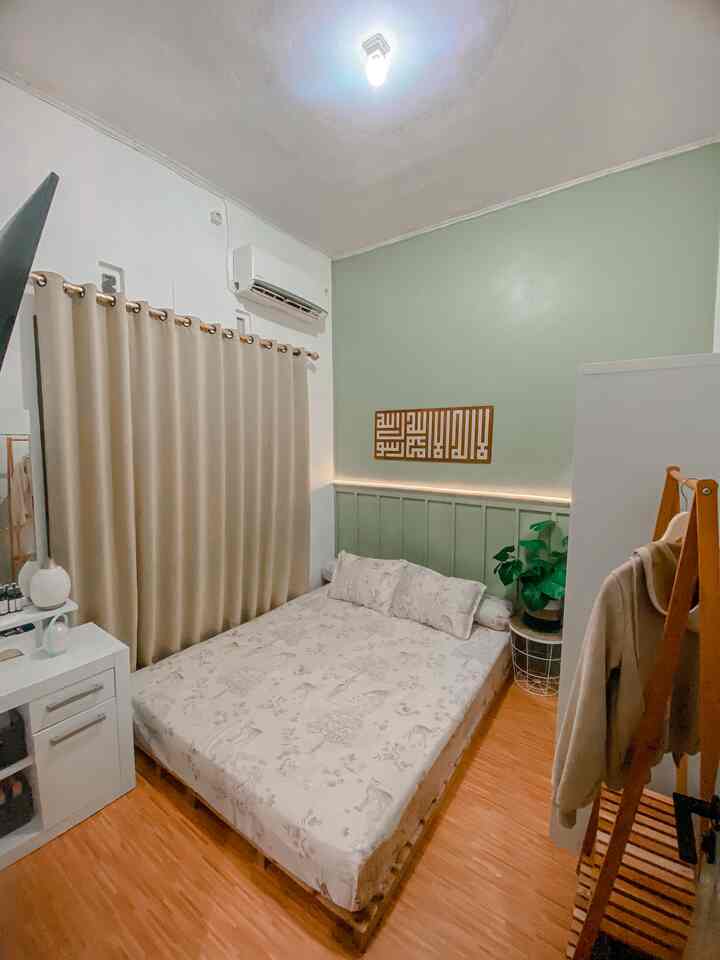 A cozy 3x2.5m small bedroom with soft green, white, and brown tones featuring a wooden floor, bed, and clothing rack