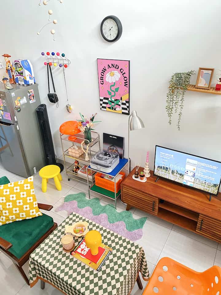 A bright living room featuring dominant green, yellow, and orange hues with a checkered tablecloth and colorful decor creating a lively atmosphere