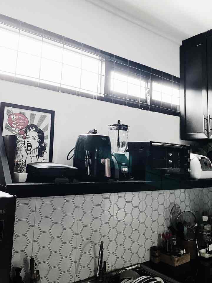 Akhirnya merasa puas dengan posisi kitchen gadget yang di susun berdampingan di ambalan dapur satu ini, pastinya setelah ubah posisi untuk ke sekian kali. Dan baru sadar kalau ternyata kitchen gadget yang ada di rumahKanawa hampir semua warna hitam.

Setiap kali styling dapur, yang di utamakan lebih ke fungsionalitas dan efektifitas aja sebenarnya, mana yang sering kepake nah itu lah yang harus “keliatan” dan mudah di ambil. 

Untuk dekorasi tidak banyak, hanya tanaman artificial sedikit dan juga satu frame pop art punya paksu yang ternyata macthing sama tema dapur. Ohya, dan juga di percantik dengan backsplash hexagon yang menurut kami jadi focal point dari dapur ini.

Inget banget waktu design dapur ini, tiap liat Pinterest tuh naksir banget sama backsplash hexagon tiles, tapiii karna balik lagi waktu itu belum nemu akun2 homedecor indo jadinya kami have no clue banget nyari yang sama persis tuh dimana 😂 trus waktu iseng2 ke Mitra10, nemu motif ini tuh happy nya luar biasaa!! Pas udah di pasang baru ngeh ternyata kok bedaaaa sama yg selama ini di liat di Pinterest wong iki mah keramiiik 30x60!! 🤣🤣🤣 tapi kami tetep puas, karna inipun bersihinnya cukup mudah. Betul-betul melengkapi tema dapur monokrom rumahKanawa! 🖤

#kitchenstyling #kitchendecorideas #kitchenmakeover #dapurhitam 
#dapur 