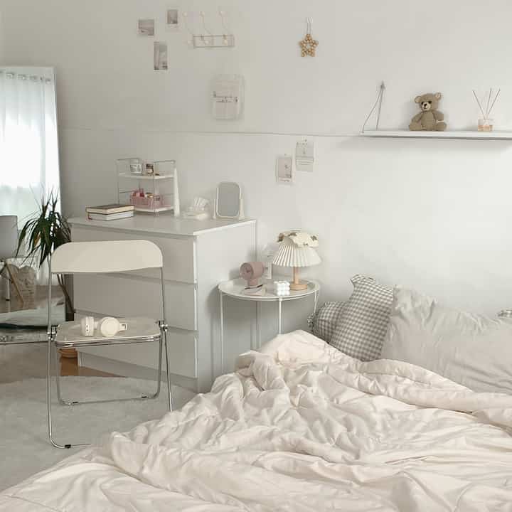Ivory and beige toned bedroom featuring a white dresser, soft bedding, and minimalist décor, creating a cozy and simple atmosphere