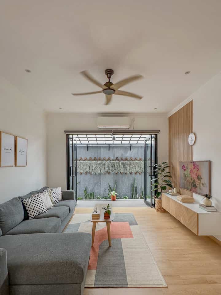Natural-toned Scandinavian style living room featuring a gray sofa, geometric patterned carpet, and wood furniture with a clean atmosphere