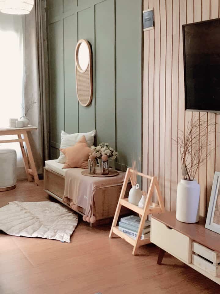 Natural wood tone entrance featuring a quilted carpet, cushions, and minimal decor creating a cozy atmosphere