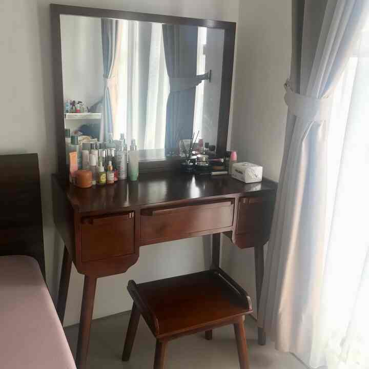 Natural color and wood tone bedroom vanity with stool creating a cozy skincare corner
