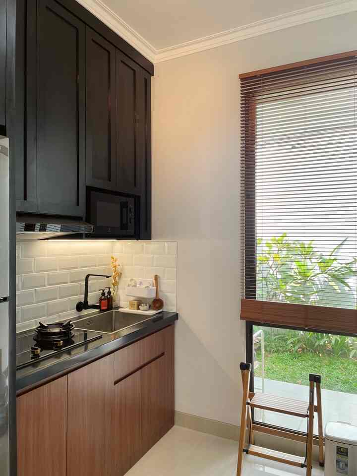 Memadukan dua warna yakni warna natural dari elemen kayu dan material-material warna hitam untuk focal point dari desain area dapur. Keberadaan kayu melenyapkan kesan kaku dari warna hitam sekaligus memberi nuansa hangat di sekelilingnya. Pada area yang sering dipakai untuk memasak, saya gunakan warna hitam supaya membersihkannya lebih mudah. Sementara untuk dinding dapur saya aplikasikan warna putih dari material keramik agar lebih terang. Dengan penggunaan keramik putih ini, saya bisa menambahkan hiasan dekorasi dried flowers di countertop, untuk membuat dapur jadi lebih berwarna. 

Area dapur ini selalu terlihat rapi, karena seluruh benda dan peralatan dapur disimpan di dalam lemari kabinet kitchen set. Kabinet kitchen set atas dimaksimalkan ke arah plafon sehingga untuk kemudahan pengambilan maupun penyimpanan barang-barang peralatan dapur menggunakan tangga yang bisa dilipat dan dipindahkan. 


#kitchenstyling
#kitchendecorideas
#kitchenmakeover
#dapurmungil
#aesthetichomedecor
#homestyling
#masterbedroom
#warmcolor
#personalizedfurniture
#moderncontemporary